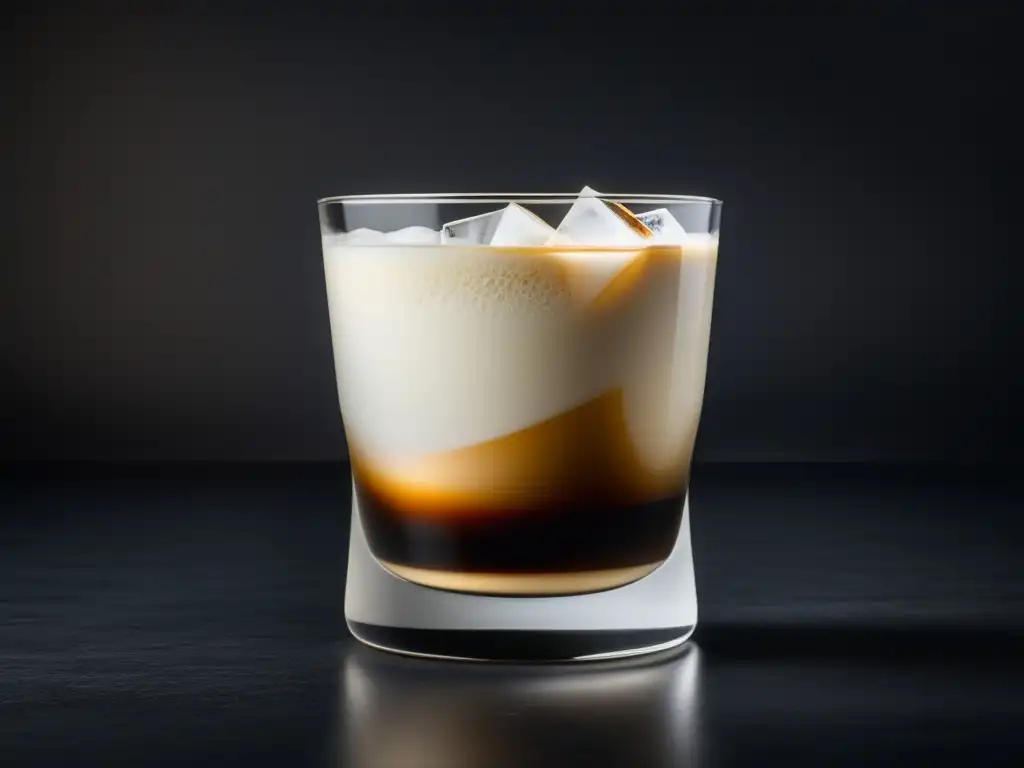 Preparar un Verdadero Cóctel White Russian - Vaso de cristal con White Russian en superficie negra